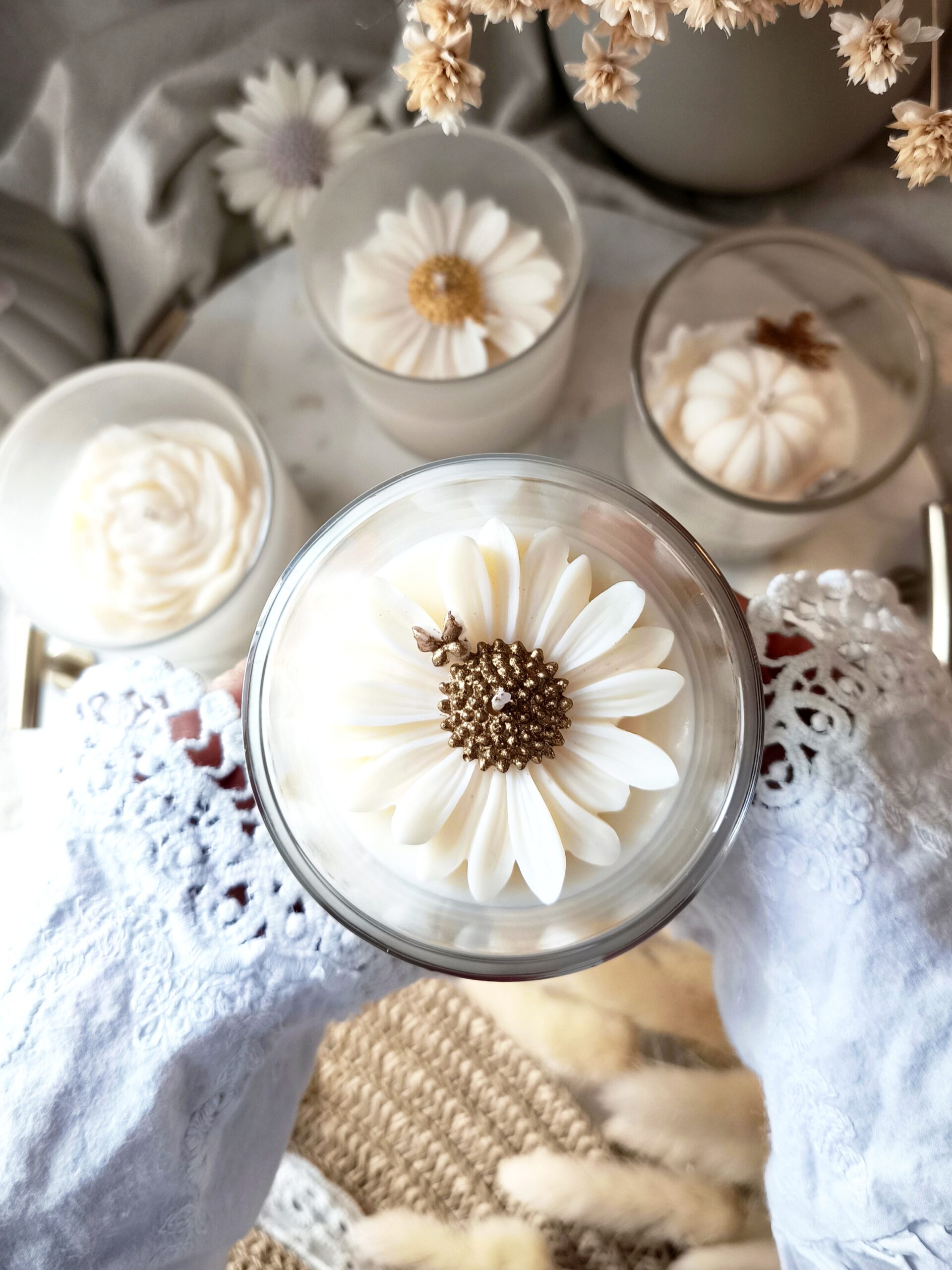 Świeca sojowa w szklanym naczyniu z bambusowym wieczkiem i woskową stokrotką ze złotym środkiem